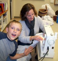 volunteers helping Sam sew